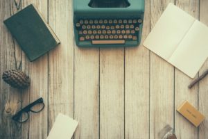 How to Create Blog Content - A Guide for Your First Blog Post vintage teal typewriter beside book