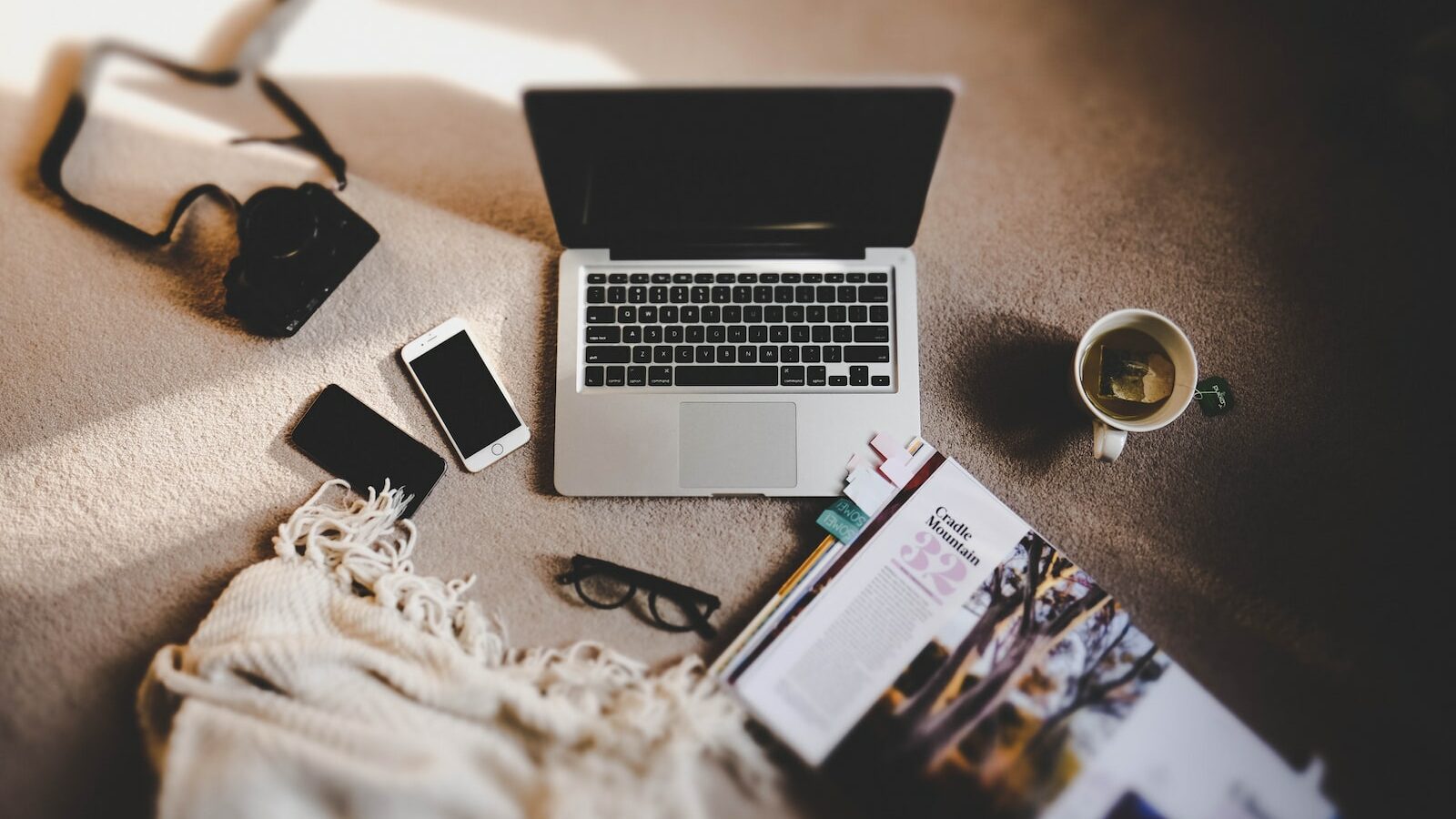 white ceramic mug near MacBook Pro