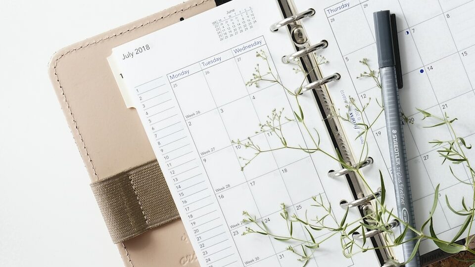 grey and black pen on calendar book